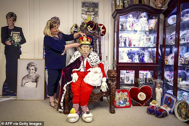 Jan Hugo adjusts a crown placed on top of a mannequin resembling Charles that makes up her collection of memorabilia of the Royal Family near Cessnock in New South Wales yesterday