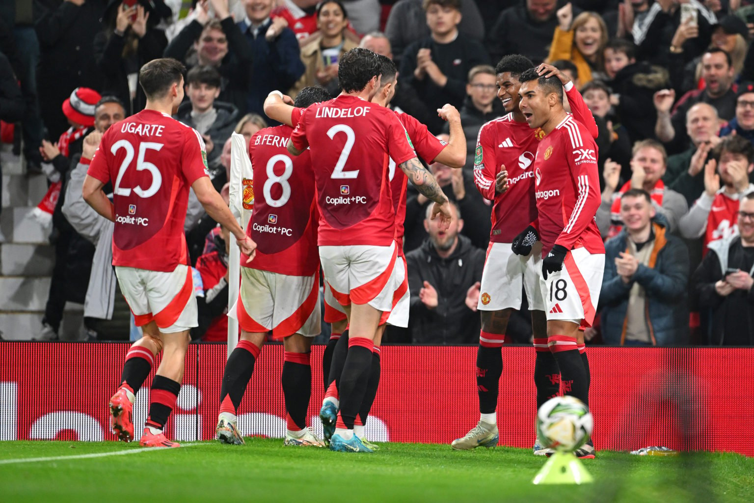 Bruno Fernandes of Manchester United (partially visible) celebrates with his teammates after scoring his team's fourth goal during the Carabao Cup ...