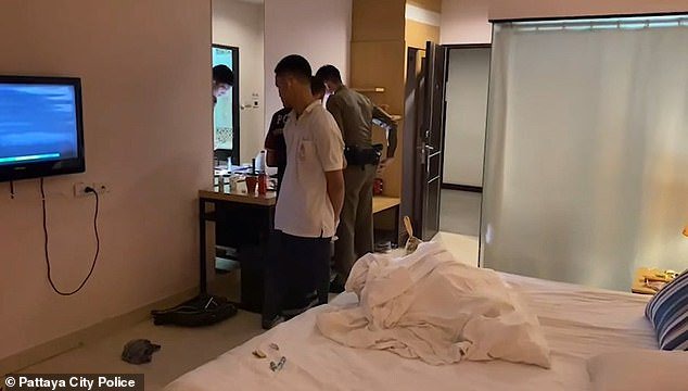 Police and hotel staff inside the room where they found the dead British national and his friend