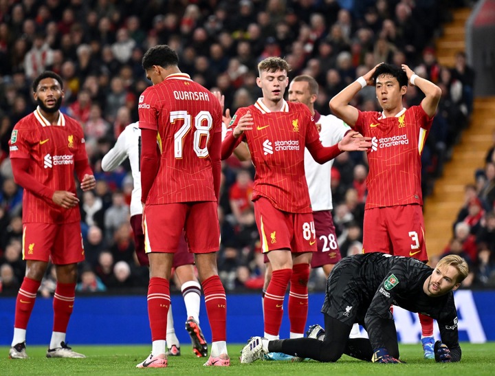 Conor Bradley, Wataru Endo and Caoimhin Kelleher of Liverpool react, after Jarell Quansah, scores a own goal and West Ham United's first during the...