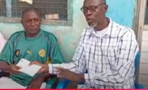 Ibrahim Merigah receiving the donation from a member of the delegation sent by John Mahama