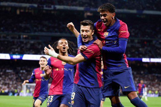 Robert Lewandowski of FC Barcelona celebrates after scoring their side's first goal with his teammate Lamine Yamal of FC Barcelona during the LaLiga match between Real Madrid CF and FC Barcelona