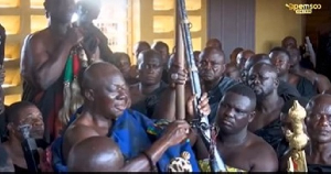 Otumfuo holding the Agyaponmaa - the gun with the bead of an Asantehene's wife