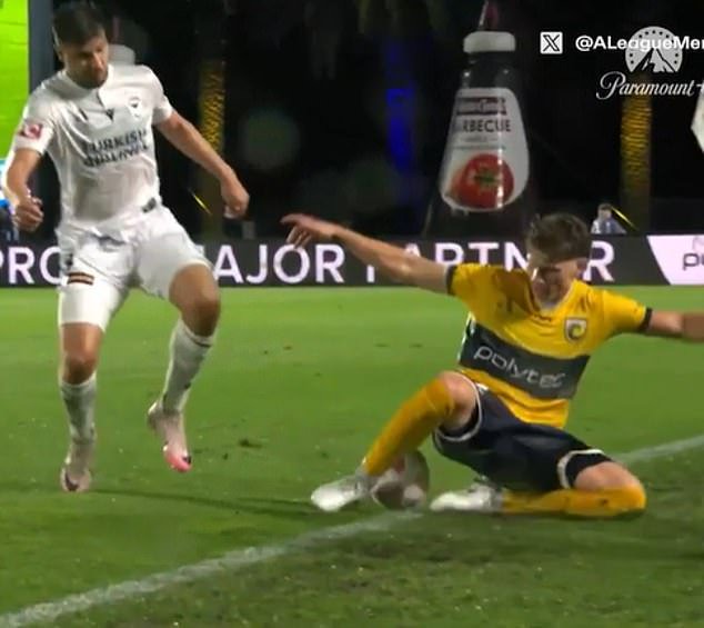 Mariners defender Lucas Mauragis (right) about to 'introduce' himself to Melbourne Victory coach Patrick Kisnorbo