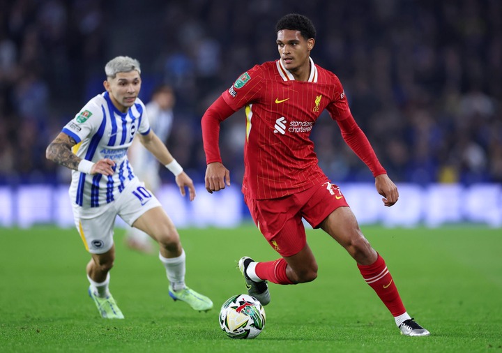 Jarell Quansah of Liverpool runs with the ball under pressure from Julio Enciso of Brighton & Hove Albion during the Carabao Cup Fourth Round m...