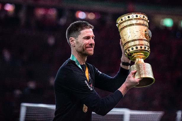 The team of Bayer Leverkusen, DFB-cup winner 2024 with Head Coach Xabi Alonso (C) celebrates victory with DFB Cup winners trophy after the DFB Cup 2023/24 final match between 1. FC Kaiserslautern and Bayer 04 Leverkusen at Olympiastadion on May 25, 2024 in Berlin, Germany.