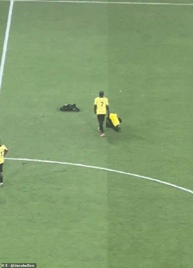 The Al-Ittihad star cleared scarves and flags off the pitch while his team-mates had a break