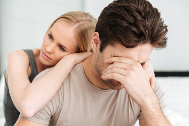 Free Photo | Pensive unhappy woman comfort her sad man while they sitting  in bed