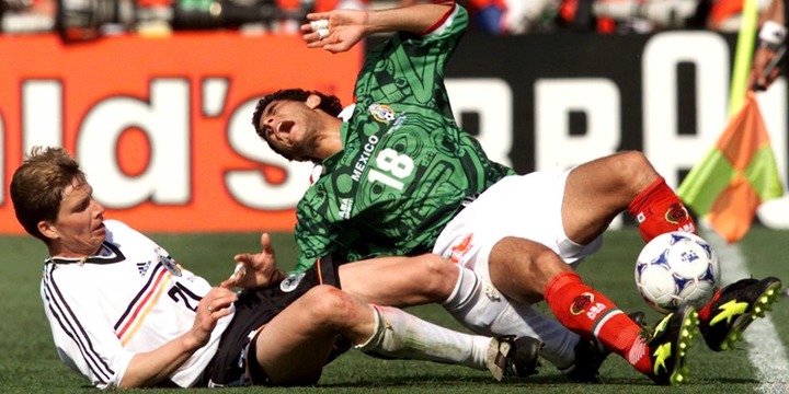 Salvador Carmona being tackled by an opposing player while in action for Mexico