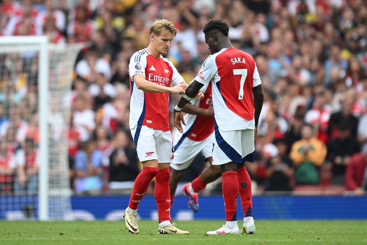 Martin Odegaard of Arsenal puts his captains armband on Bukayo Saka of Arsenal after being substituted off during the Premier League match between ...