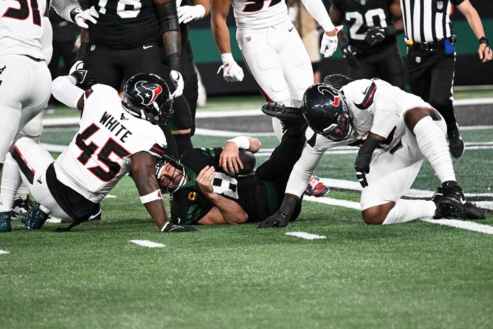 Jets quarterback Aaron Rodgers (8) is sacked by Houston Texans defensive end Denico Autry (96) and linebacker Devin White (45) during the first quarter of the Jets and Houston Texans game in East Rutherford, NJ. 