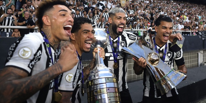 Botafogo players pose for a photo with the Brasileiro Championship trophy and Copa Libertadores trophy in front of the fans