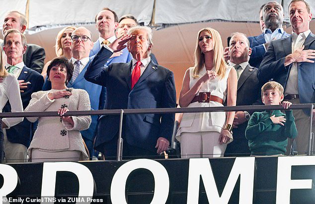 President Donald Trump, center, New Orleans Saints owner Gayle Benson, left, and Ivanka Trump, right, stand for the national anthem