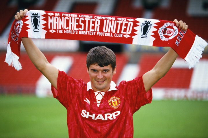 New Manchester United signing Roy Keane poses with a club scarf at Old Trafford after signing from Nottingham Forest ahead of the 1993/94 season.