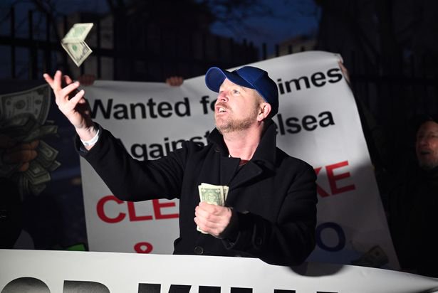 A fan of Chelsea is seen throwing dollar bills during a protest against BlueCo