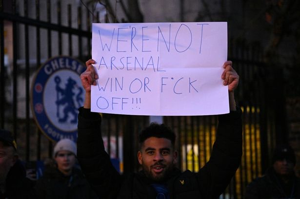 A supporter outside the Chelsea gates with a sign protesting the ownership