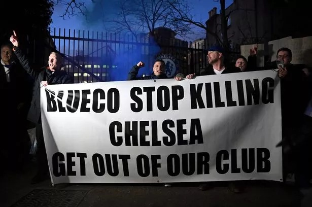 Fans of Chelsea are seen holding a banner as they protest against BlueCo. It reads: 'Stop killing our club'