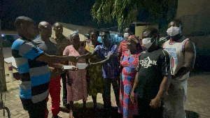 Ernestina Ofori Dangbey, presenting the money to the family of Stephen