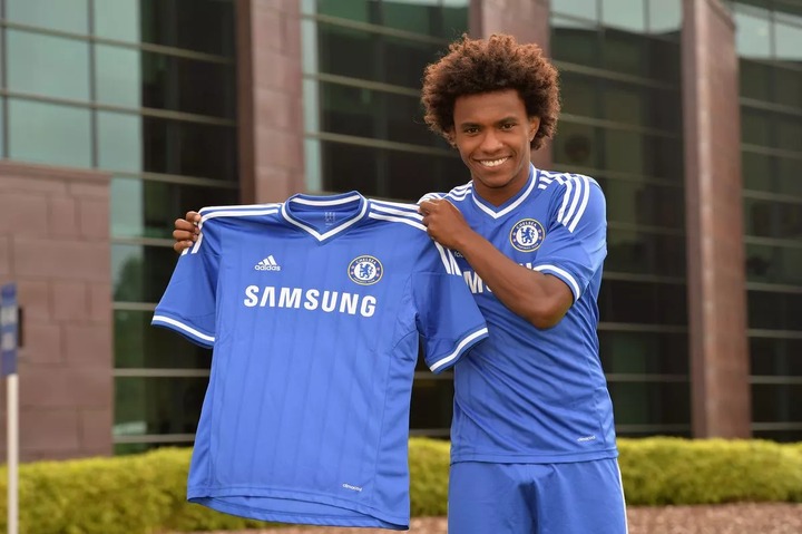 Chelsea's Willian in the Chelsea kit holding the home shirt