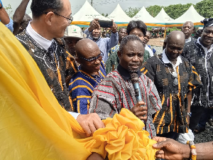 Kwabena Minta Akandoh being supported to official cut tape for the health centre to be opened