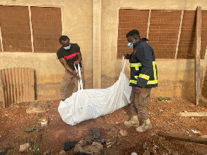 GNFS personnel carrying the decomposed body in a body bag