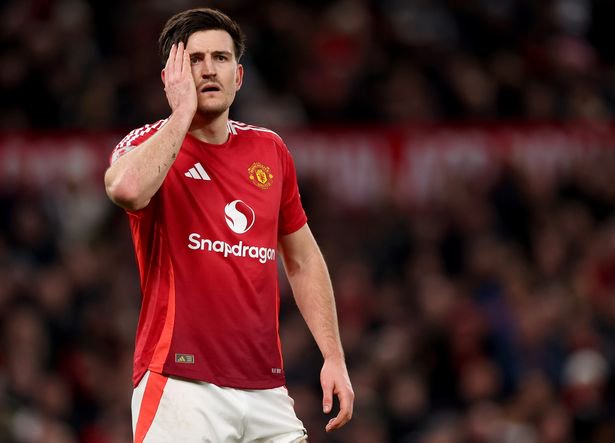 Harry Maguire holds the right side of his side with his right hand.