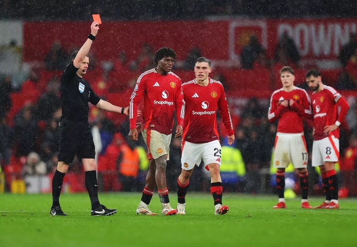 Patrick Dorgu of Manchester United is shown a red card by Darren England