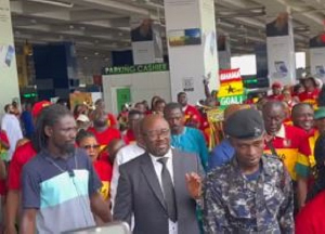 Kurt Okraku (in black suit) received heroic welcome at the airport